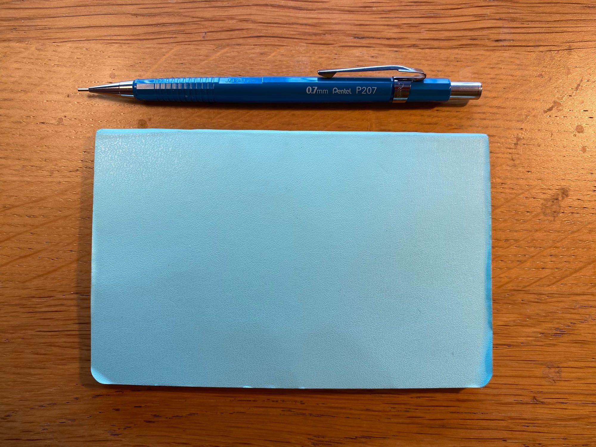 A Pentel automatic pencil on a pocket Moleskine notebook