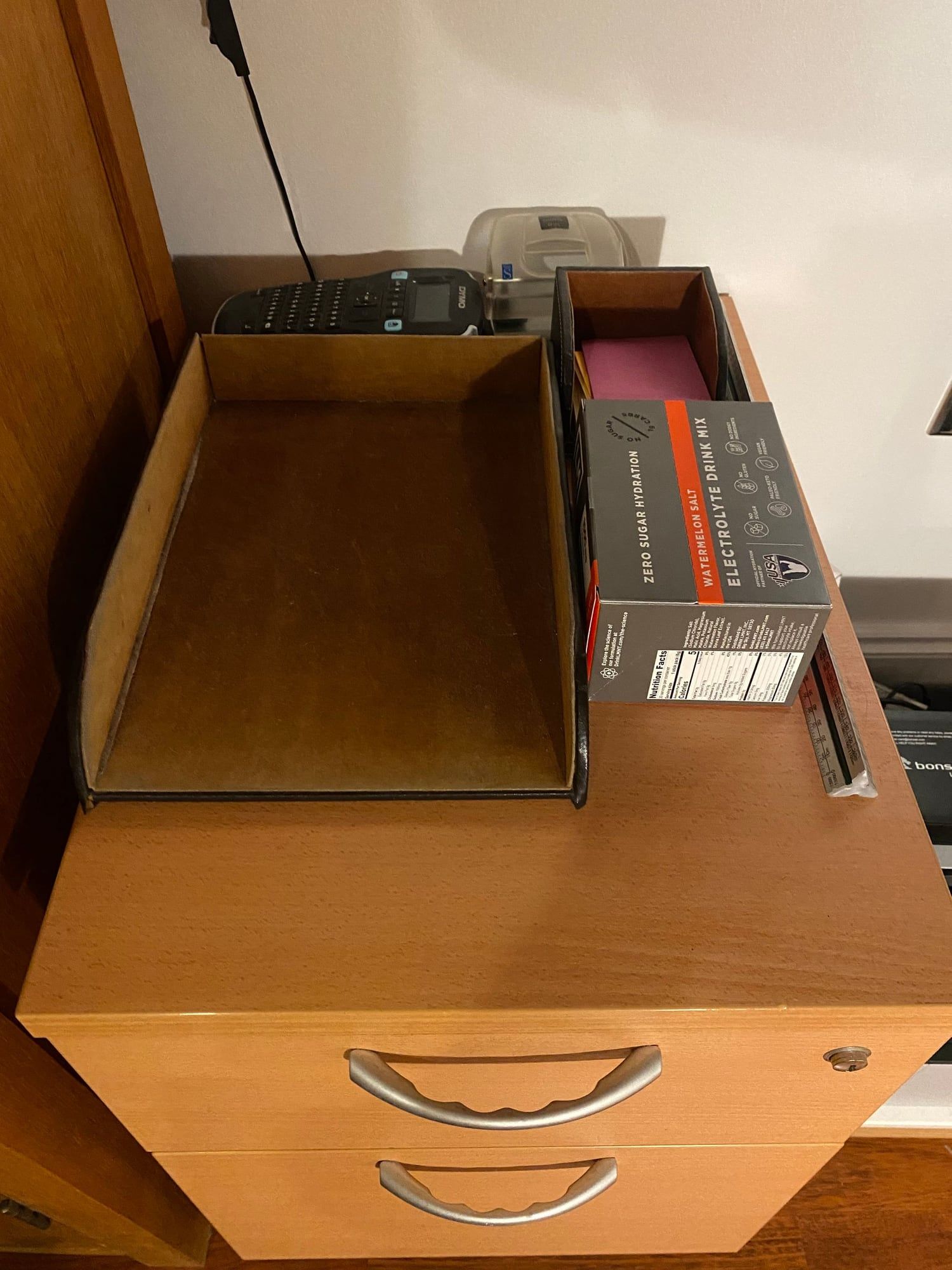 The top of the filing cabinet with an in-tray and post-its