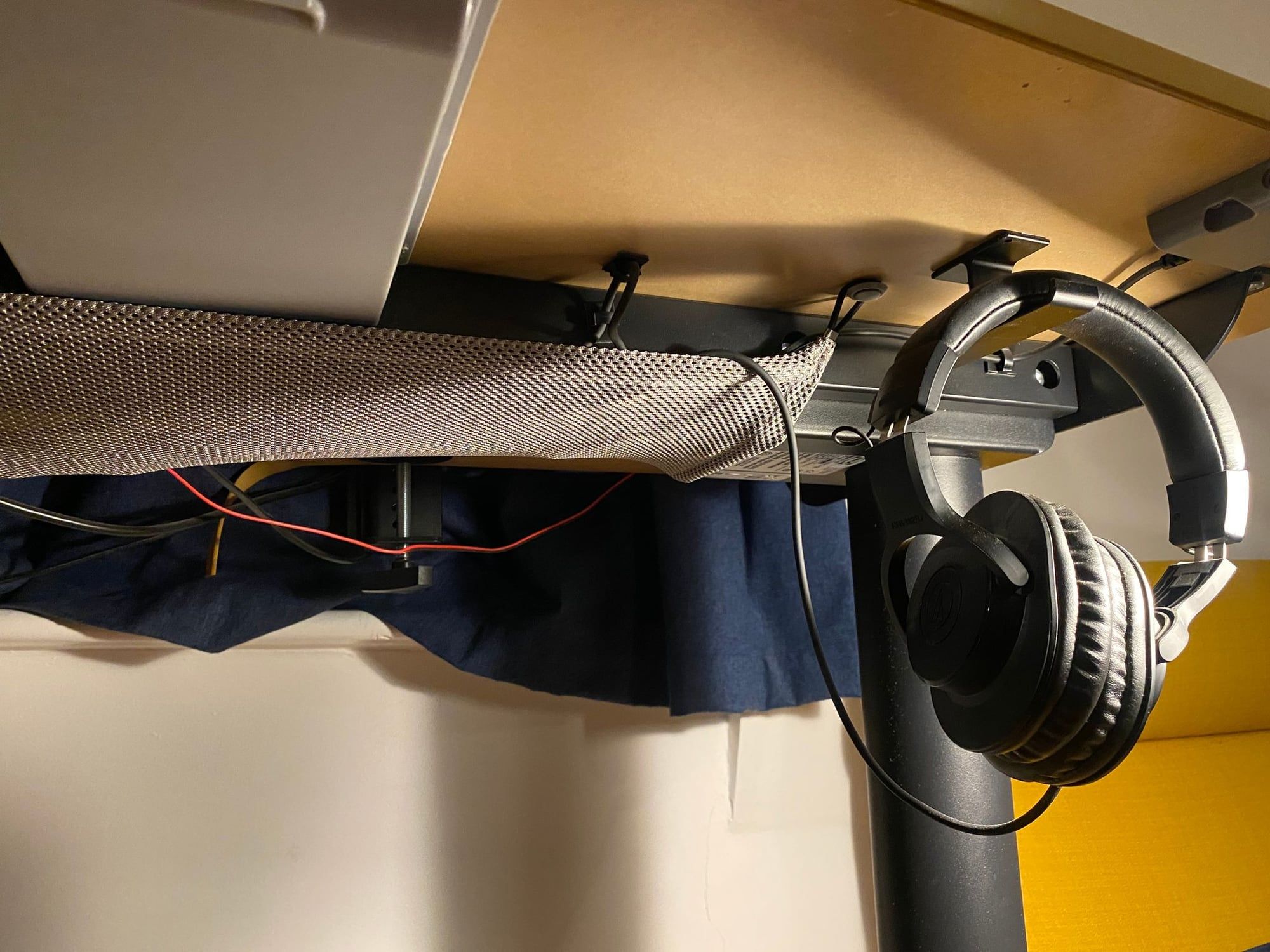 Headphones hanging from an under-desk hook